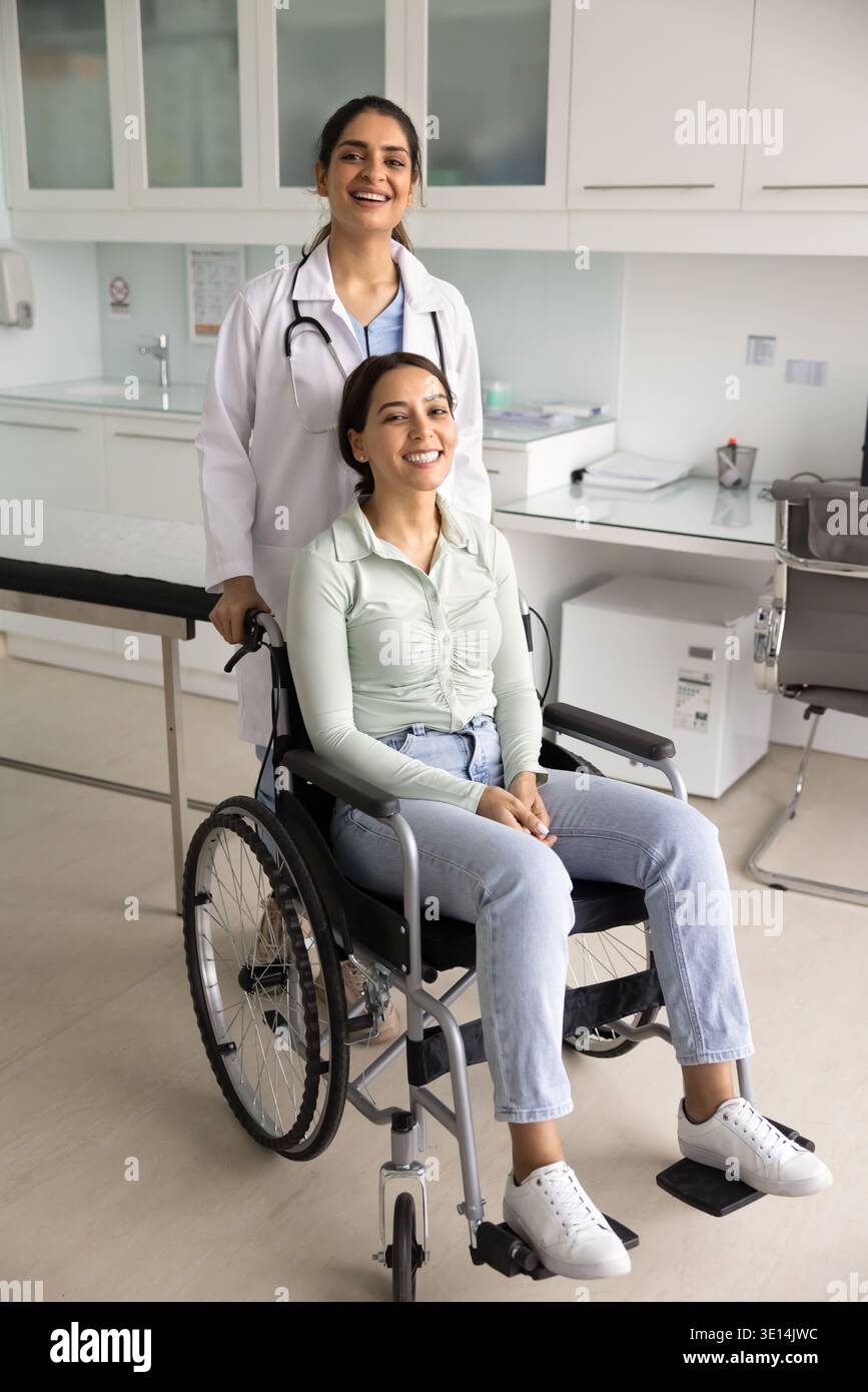 Porträt eines Arztes, der hinter einer Patientin im Rollstuhl steht Stockfoto