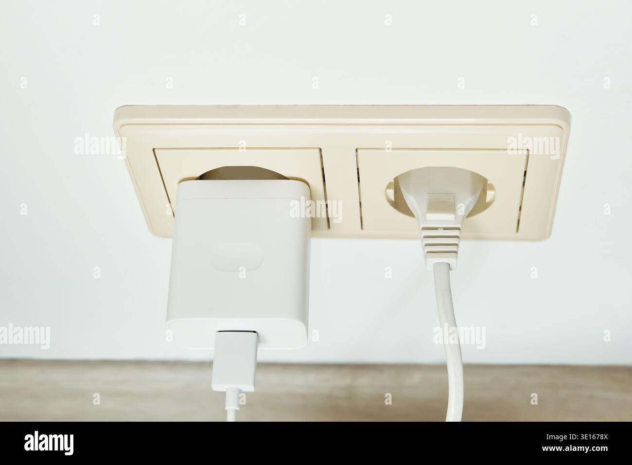 Steckdose mit Ladegerät und Netzstecker zur Stromversorgung Stockfoto