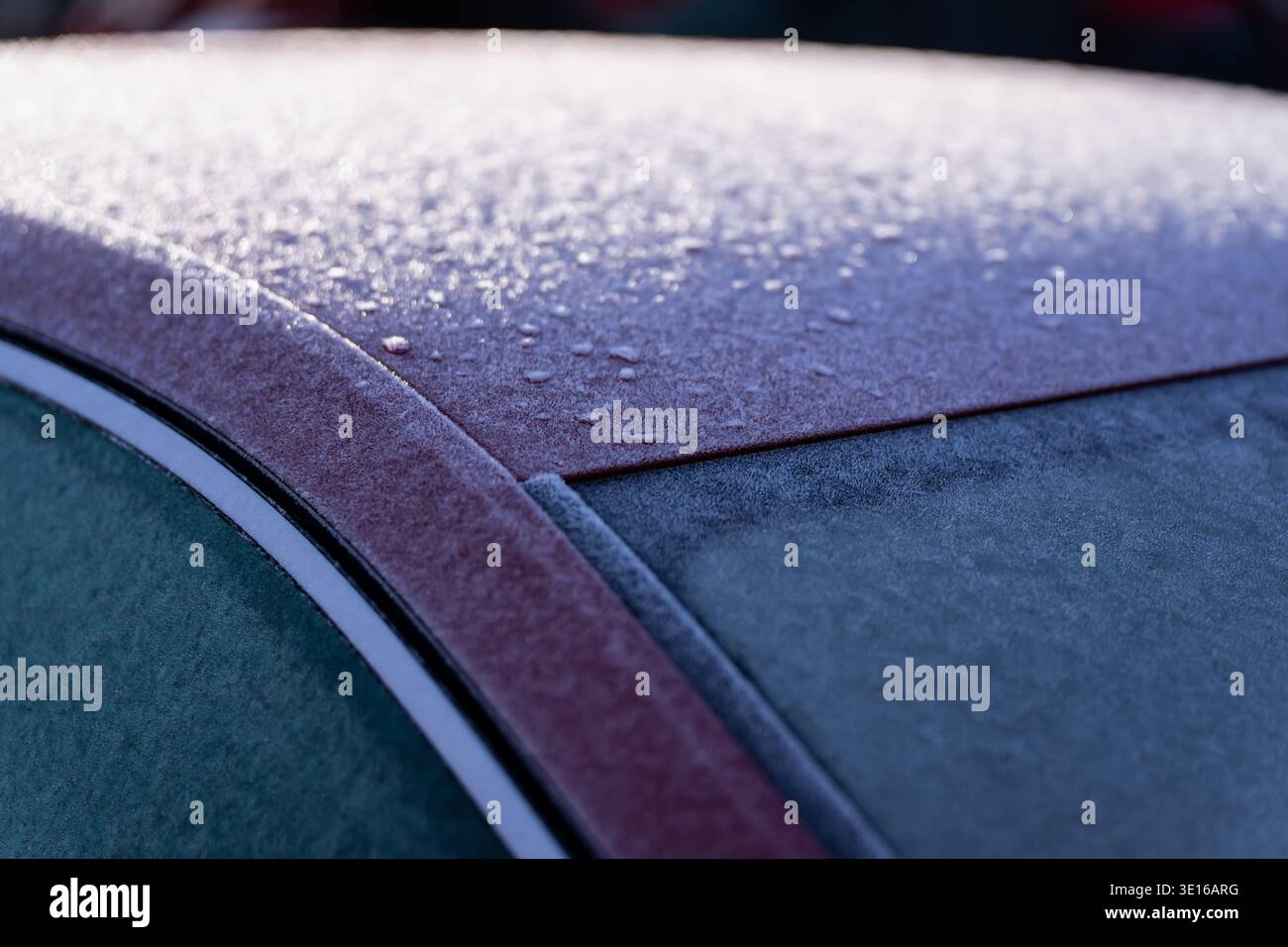 Frostbedecktes rotes Autodach mit gefrorenen Seitenscheiben und Wassertropfen, veranschaulicht die Winterbedingungen des Fahrzeugs, kalte Vormittage und saisonale Transporte ca. Stockfoto