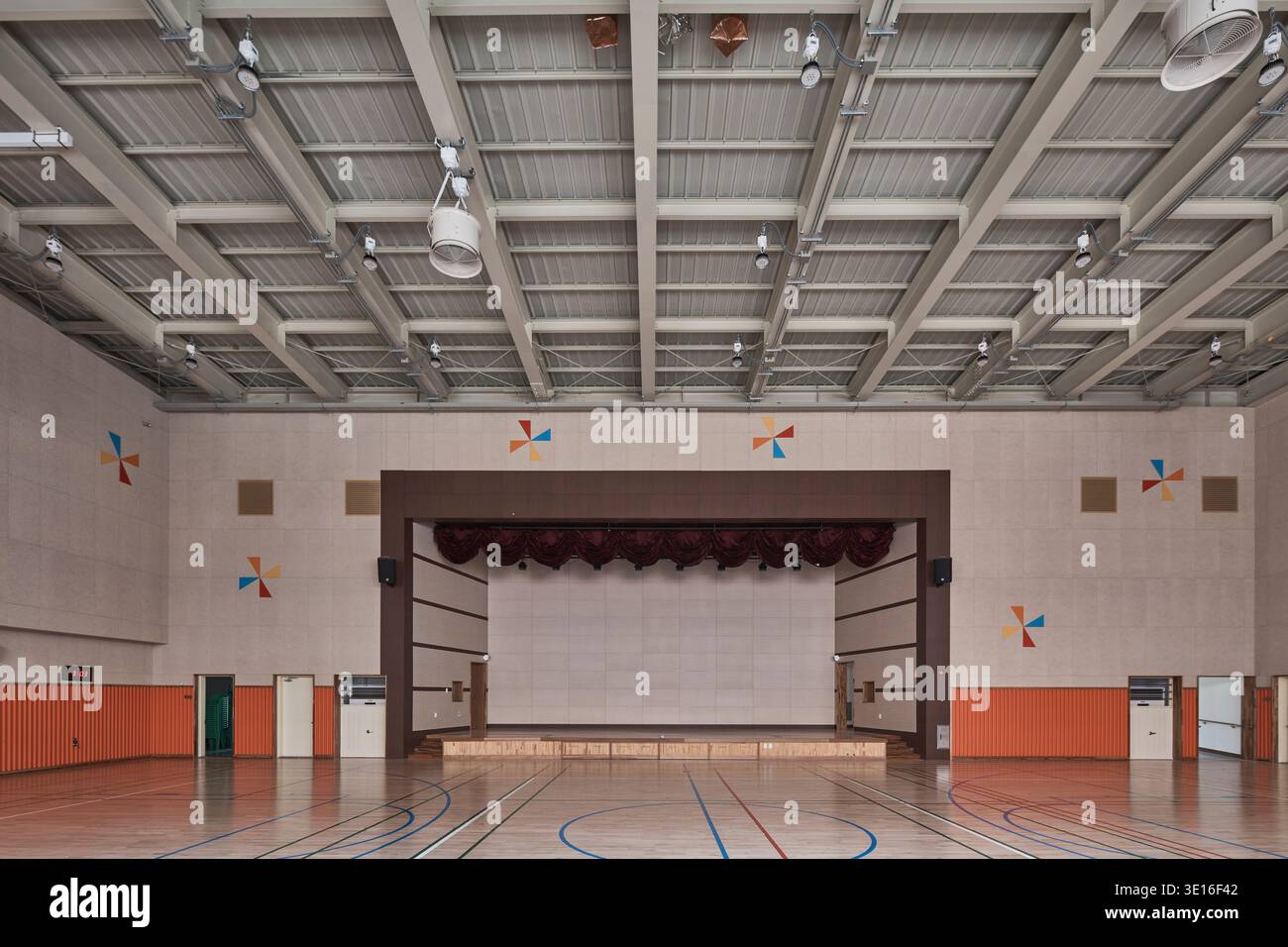 Leeres Schulgymnasium mit poliertem Boden und Bühne. Stockfoto