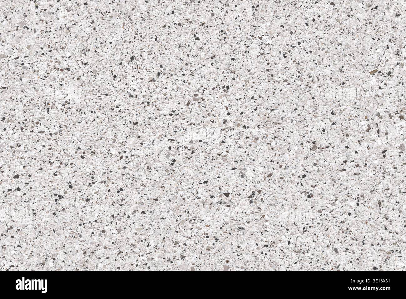 Makroansicht kleiner Quarz- und Granitsteinchen auf weißem Hintergrund. Dichte mineralische Struktur, ideal für Bau, Innenarchitektur und Archit Stockfoto