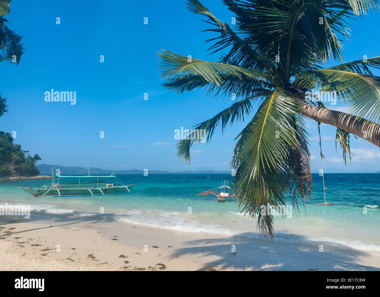 Palmen umgeben türkisfarbenes Wasser und traditionelle Auslegerboote am Maxima Island Beach, Palawan, Philippinen, während Port Barton Island Hopping. - Smartphone-aufgenommenes Stockfoto