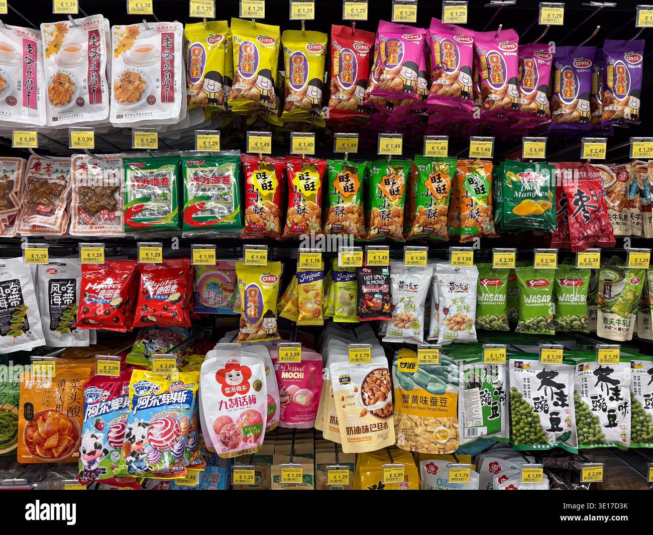 Die Regale waren mit verschiedenen asiatisch abgepackten trockenen Snacks, Süßigkeiten und Süßigkeiten ausgestattet, die in Euro bezahlt wurden. Italienischer Lebensmittelmarkt. Stockfoto