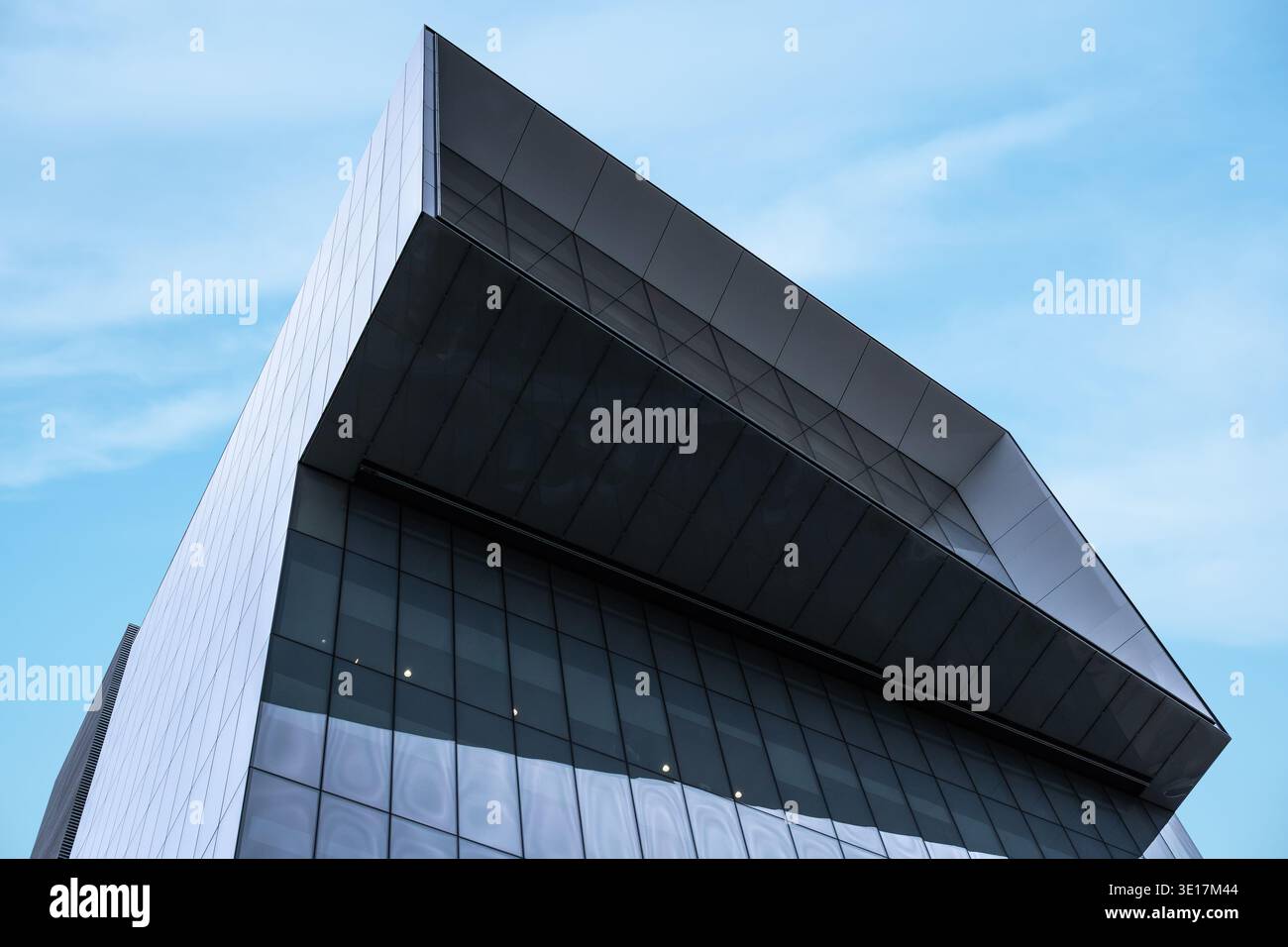 Ein moderner Büroturm mit schlankem architektonischem Design, klaren Linien und großen Glasfenstern, überragt vor dem Hintergrund einer vibra Stockfoto