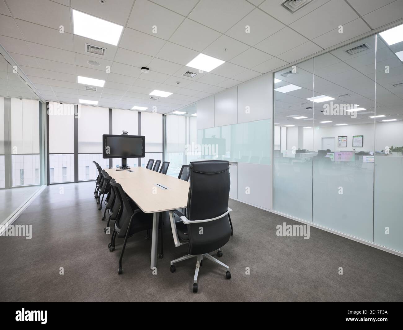 Tagungsraum mit langem Tisch und Videodisplay. Stockfoto