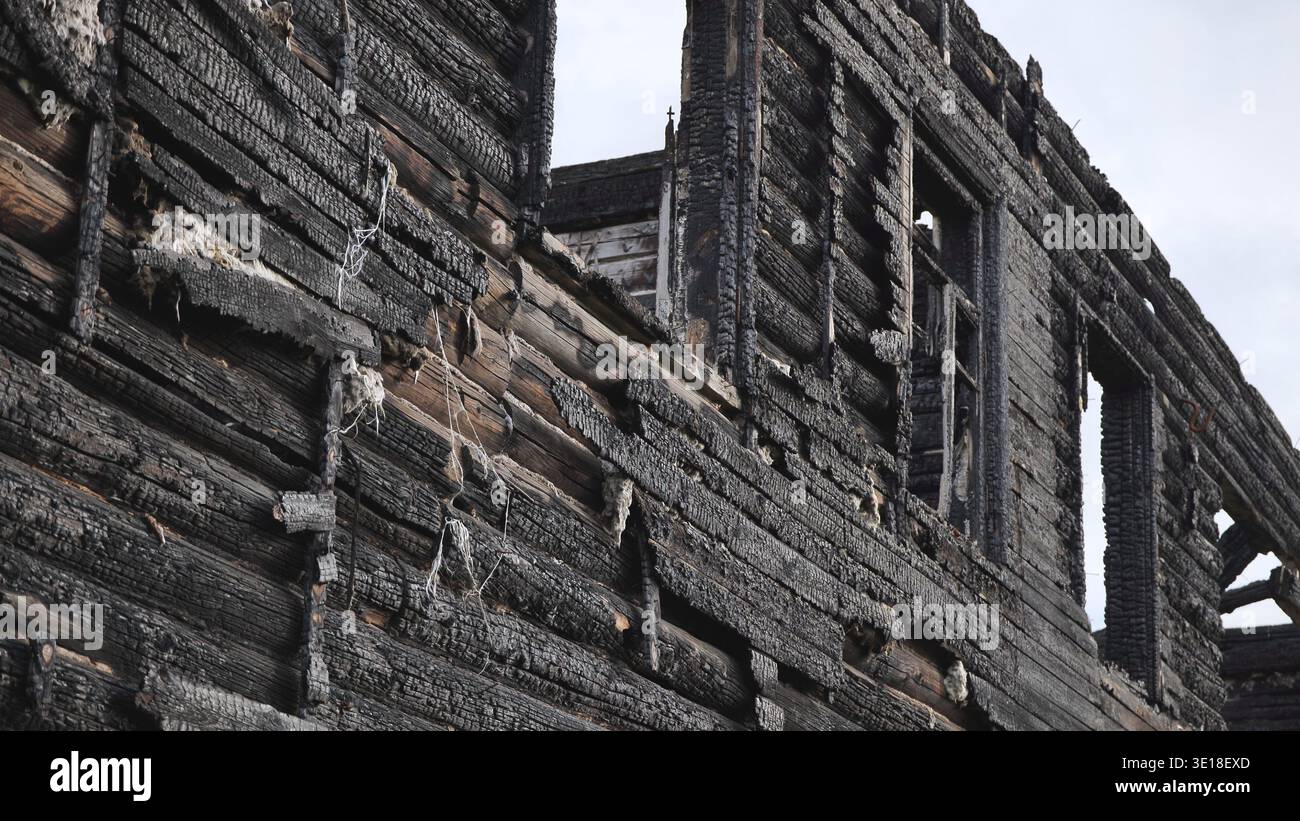 Verkohlte Holzwand eines durch Feuer zerstörten Gebäudes, rustikale Ruinen Stockfoto