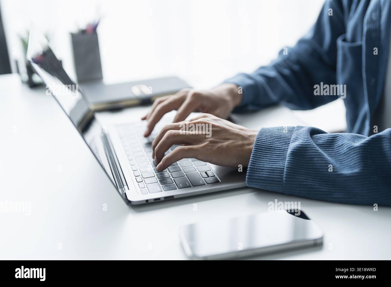Mann, der mit einem Laptop arbeitet, Hände auf der Tastatur tippen. Schreiben eines Blogs. Die Arbeit zu Hause ist in der Hand der Schreibmaschine Stockfoto