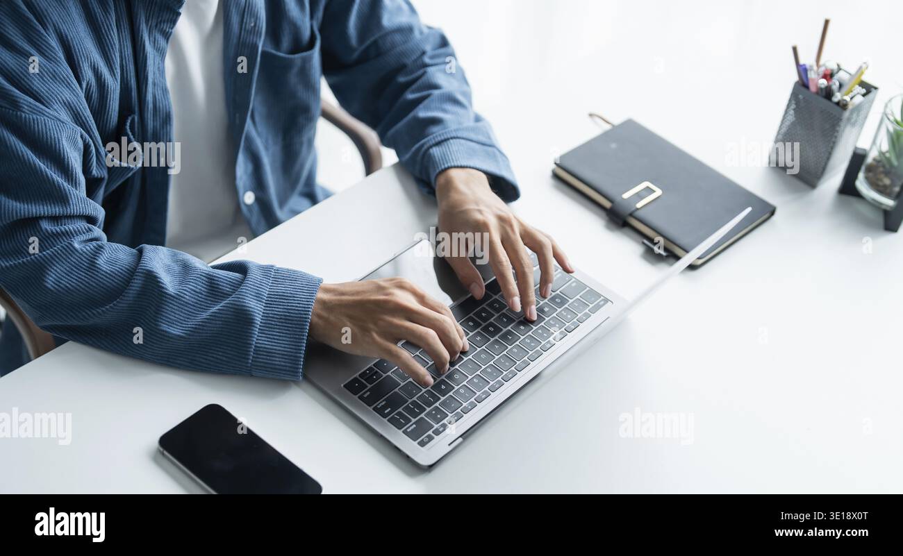 Mann, der mit einem Laptop arbeitet, Hände auf der Tastatur tippen. Schreiben eines Blogs. Die Arbeit zu Hause ist in der Hand der Schreibmaschine Stockfoto