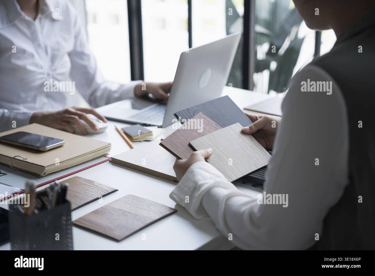 Innenarchitektin präsentiert umweltfreundliche Holzmaterialmuster für nachhaltige Wohnkultur Stockfoto