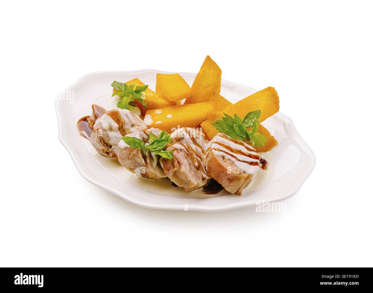 Gegrillte Hähnchenspieße werden kunstvoll auf einem weißen Teller zusammen mit lebhaften Mangoblättern angeordnet. Frische Kräuter verleihen diesem Appeti einen Hauch von Farbe Stockfoto