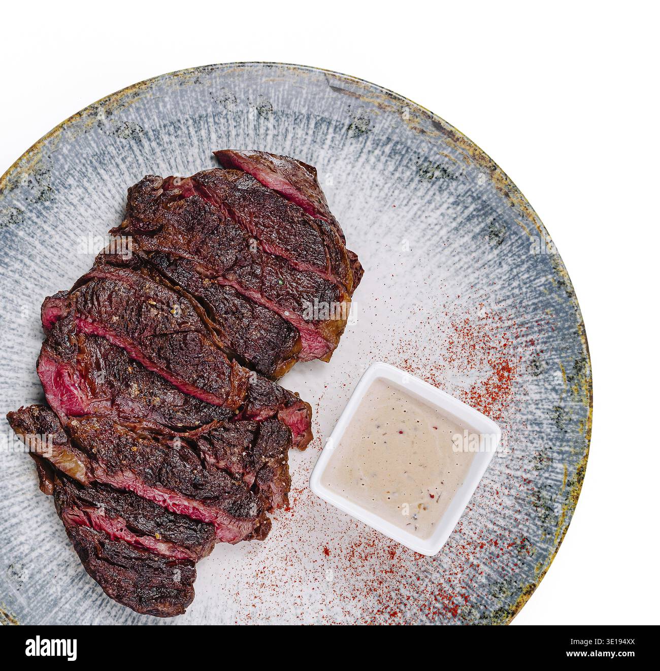 In Scheiben geschnittenes gegrilltes Rindersteak mit Gewürzen und Sauce auf dem Teller serviert Stockfoto