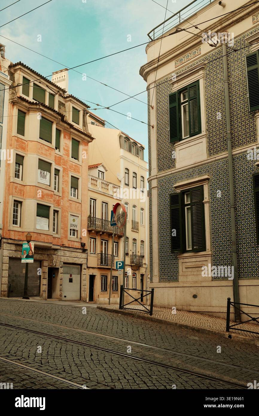 Historische Straße mit pastellfarbenen Gebäuden und traditioneller Architektur in Lissabon, Portugal. Stockfoto