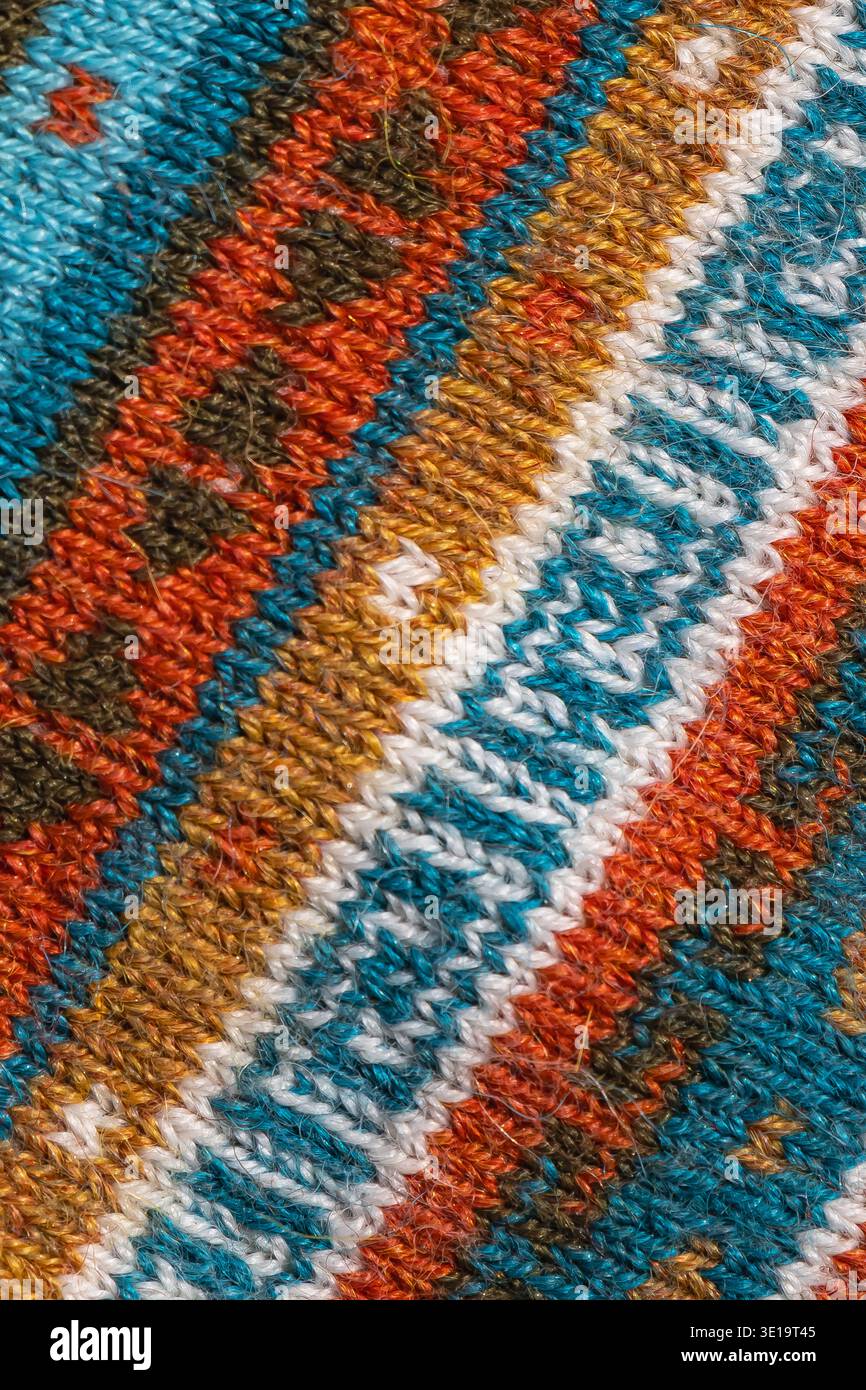 Makroaufnahme aus farbenfrohem, traditionellem Gewebe mit geometrischem Streifenmuster und detaillierten Fäden in Türkis, Orange, weiß und Braun. Stockfoto