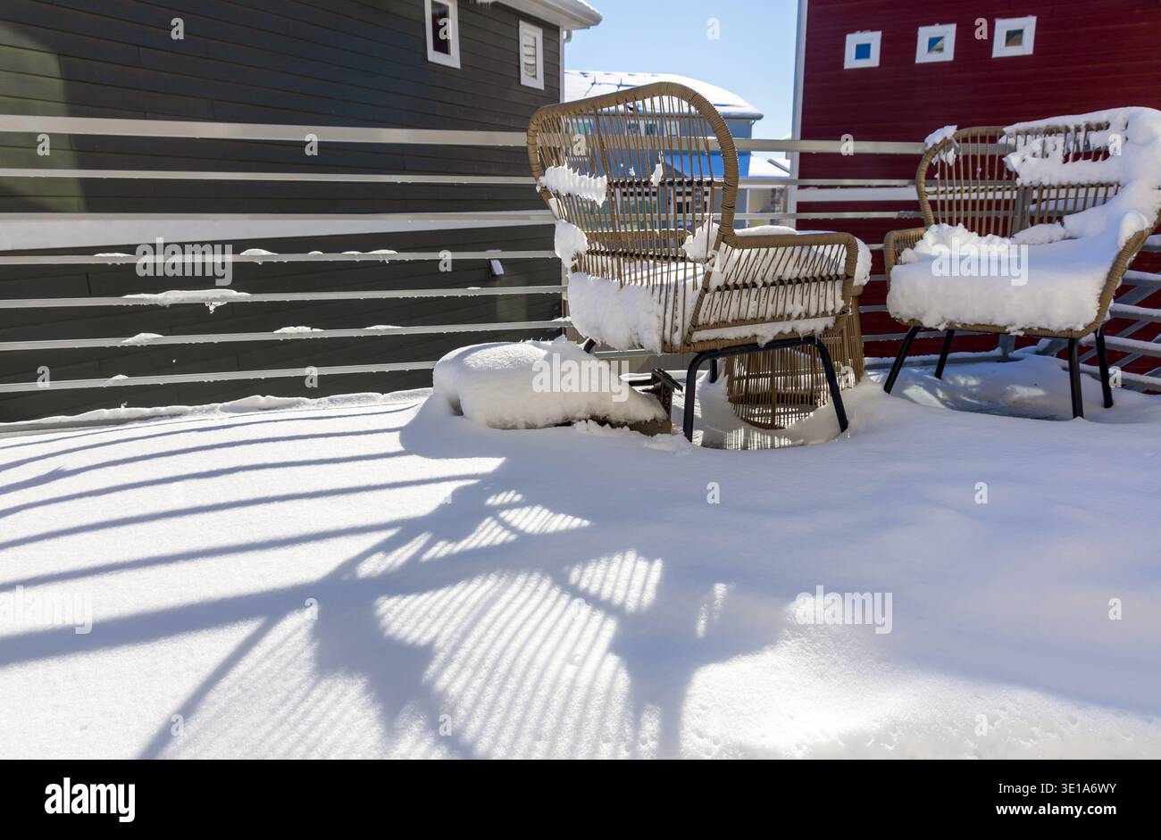 Schneebedeckte Stühle und ein Tisch auf dem Balkon nach einem Wintersturm Stockfoto