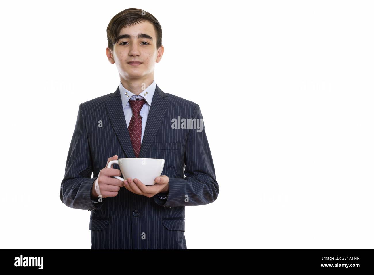 Studioaufnahme eines jungen, hübschen persischen Teenagers, der Kaffee hält becher Stockfoto