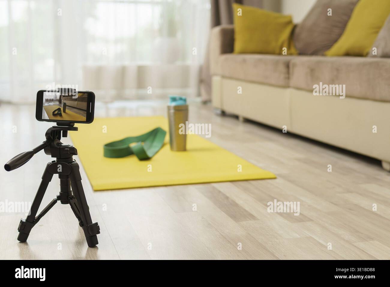 Smartphone auf einem Stativ, das Videos mit einem Gerät für das Heimtraining aufnimmt. Konzepte des Online-Fitnesstrainings oder Vlogging Stockfoto