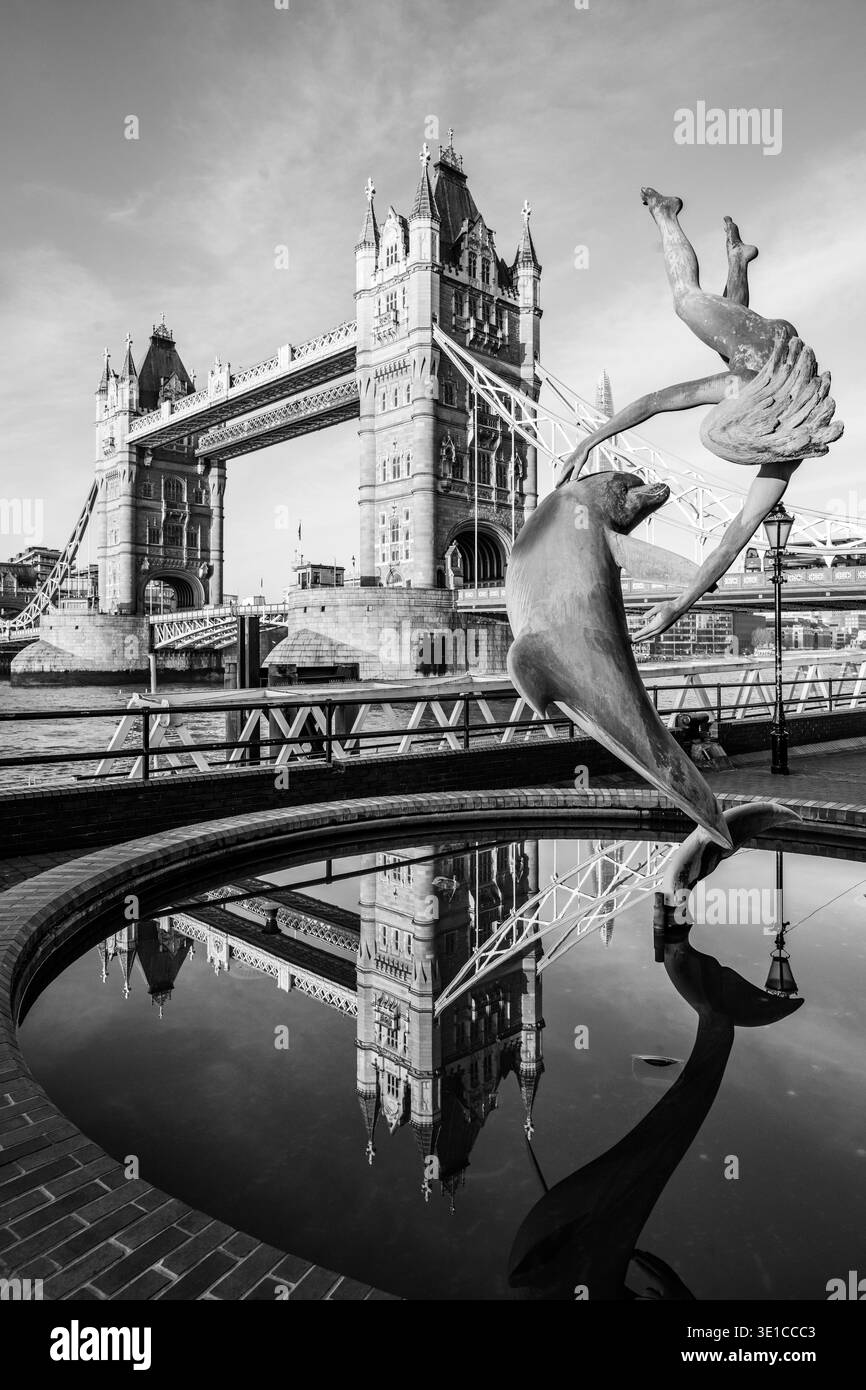 Girl with a Dolphin – die Statue eines Mädchens, das mit einem Delfin spielt, steht in der Nähe der berühmten Tower Bridge in London. Das Kunstwerk verfügt über eine reflektierende Oberfläche, die die bezaubernde Szene der Stadt unterstreicht. Stockfoto