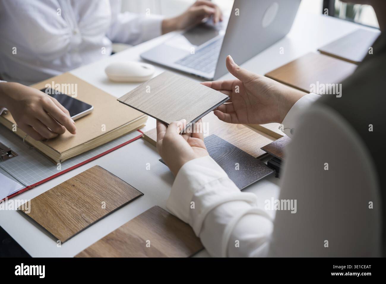 Innenarchitektin präsentiert umweltfreundliche Holzmaterialmuster für nachhaltige Wohnkultur Stockfoto