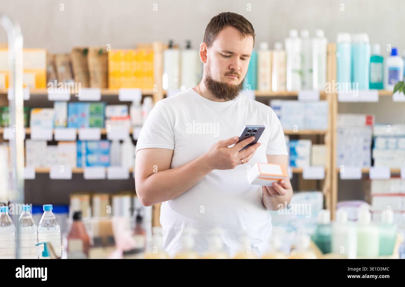 Junger Mann, der den qr-Code von Pillen scannt Stockfoto