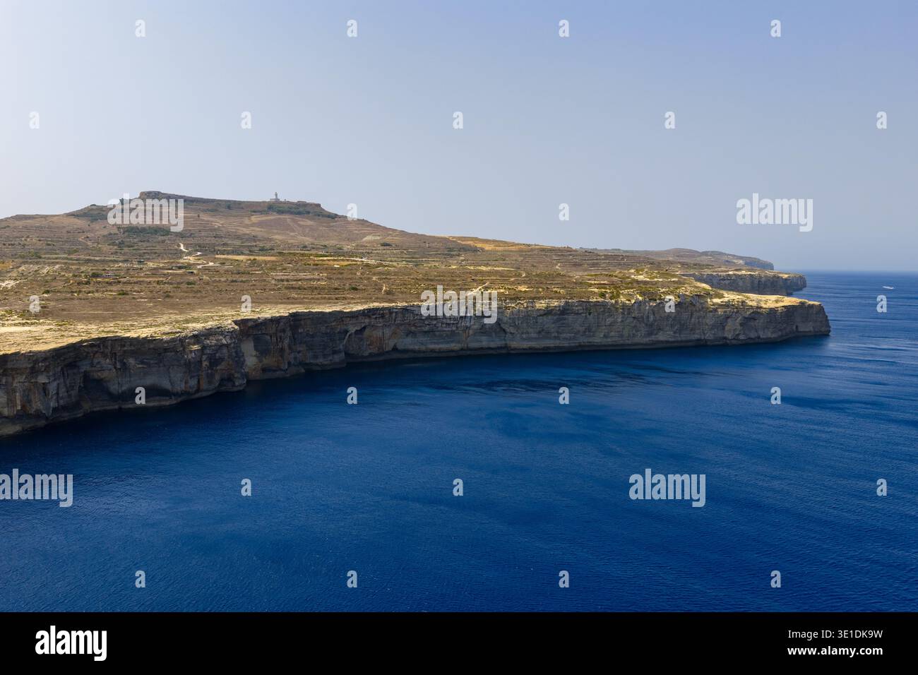 Felsige Kalksteinspitze am Reqqa Point in der Nähe von Zebbug, Malta, mit zerklüfteten Klippen mit Blick auf das tiefblaue Mittelmeer unter klarem Himmel. Stockfoto