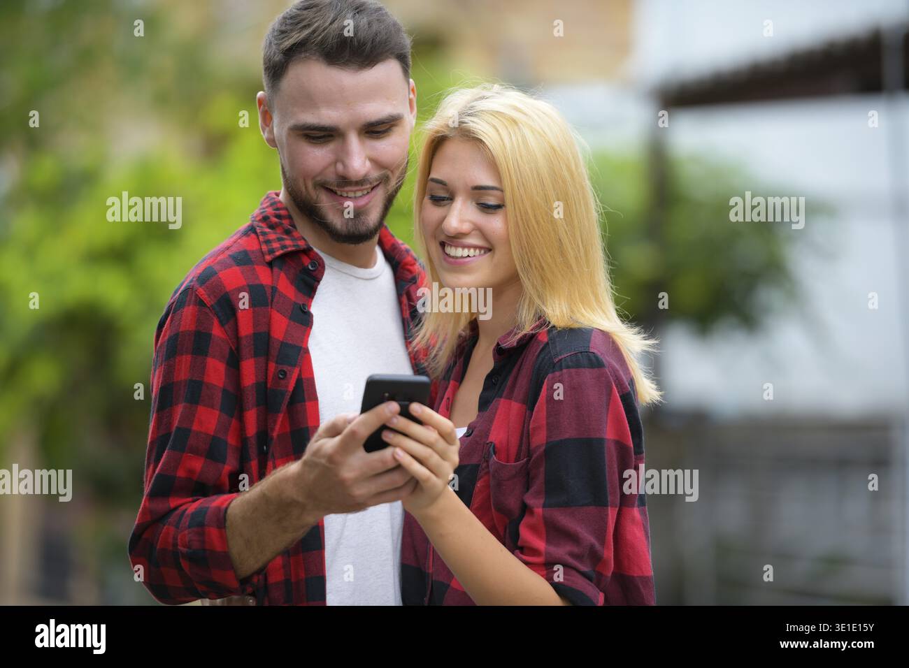 Porträt eines jungen gutaussehenden bärtigen Mannes und einer jungen schönen blonden Frau, die draußen auf der Straße sind Stockfoto