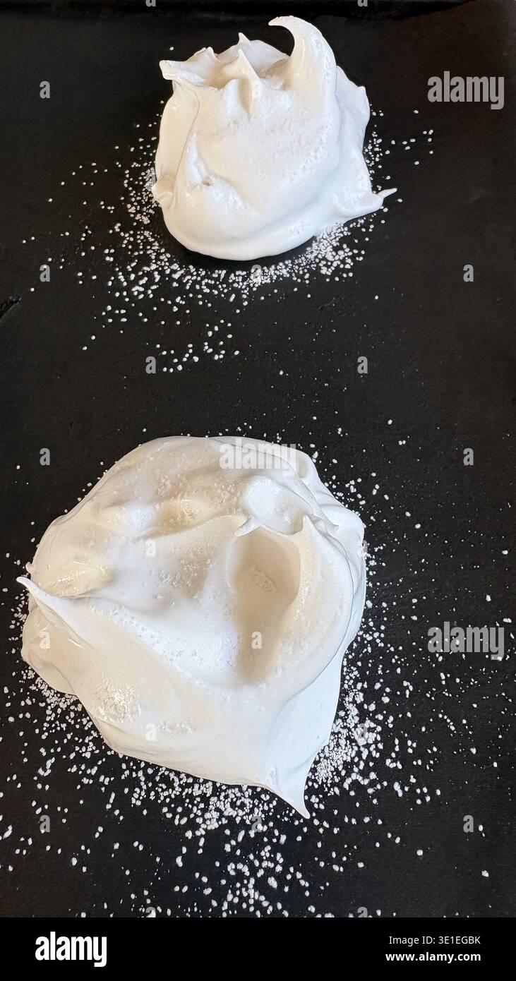 Zwei vorgebackene Aquafaba-Baisons auf dunkler Oberfläche (kein Ei) Stockfoto