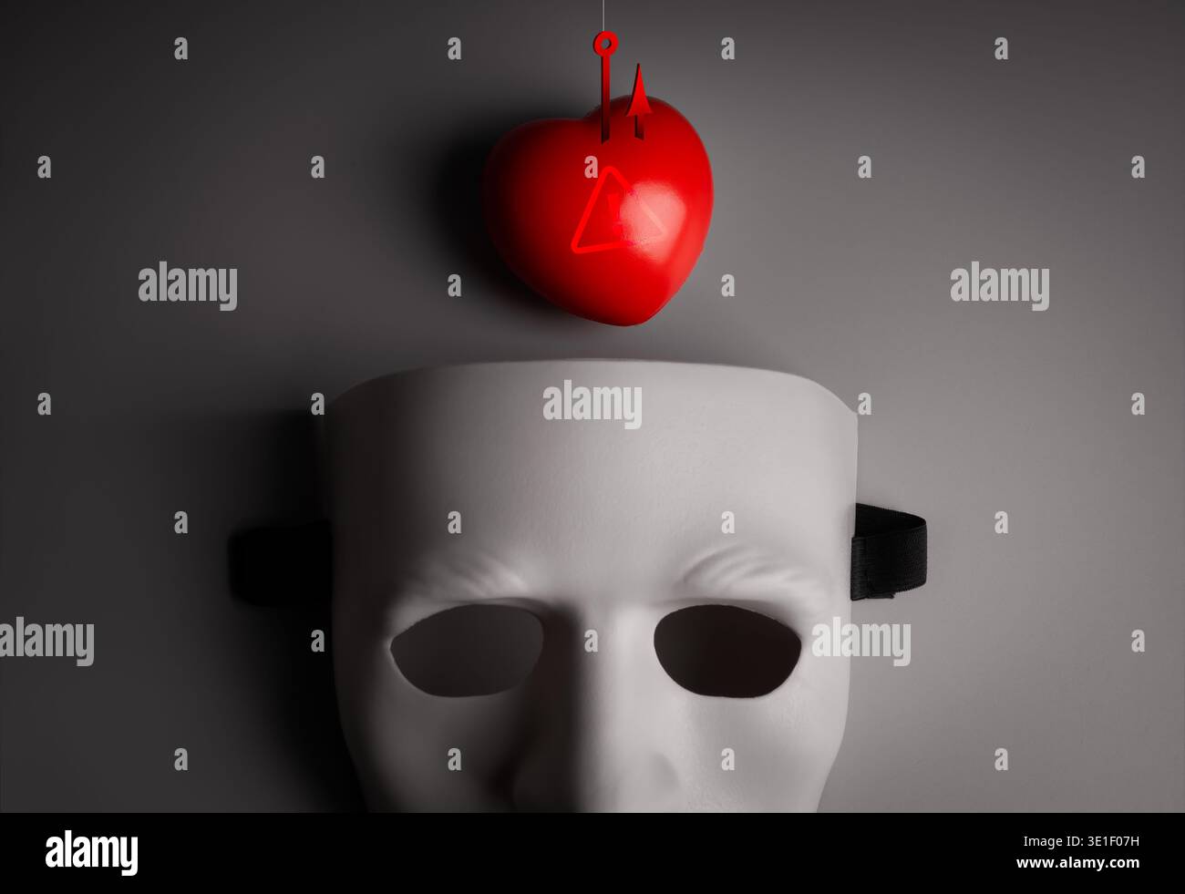 Rotes Herz als Köder über einer leeren anonymen menschlichen Maske. Romantik-Betrug, falsche Liebesmanipulation und emotionale Täuschung durch Betrüger. Das Konzept des Onlins Stockfoto