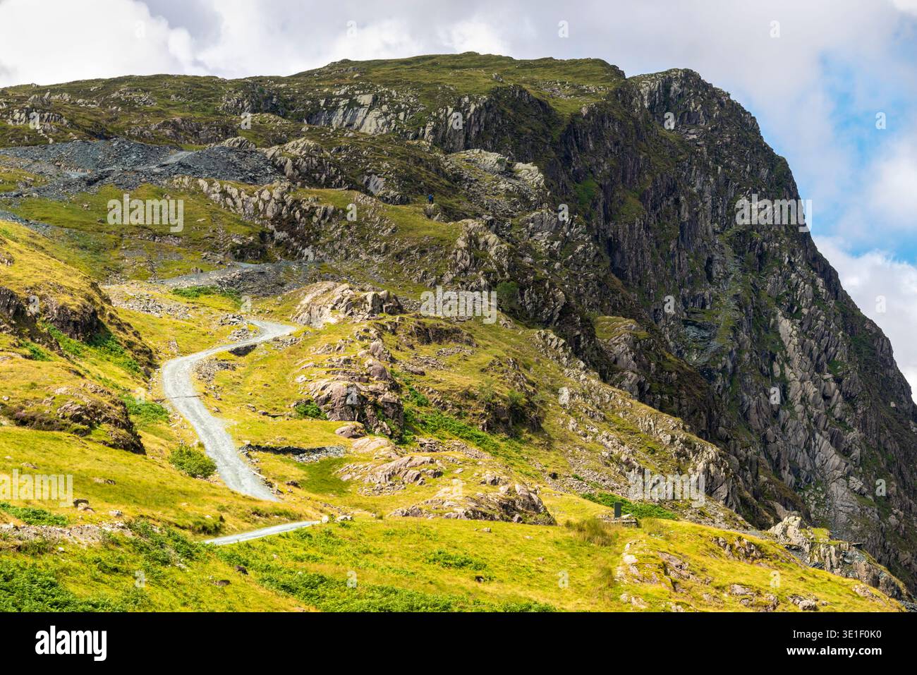 Dramatische Landschaft mit steiler Schlangenstraße, die an einem warmen, sonnigen Mittsommertag auf einen felsigen Berg von Cumbrian führt, von der Honister Slate Mine. Stockfoto