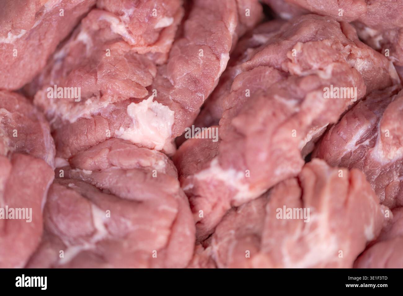 Gefrorenes Schweinefleisch. Gekühltes Schweinefleisch mit eisiger Oberfläche. Fleisch kalt gehalten mit Frost auf der Oberfläche. Gefrorenes Schweinefleisch mit Eiskristallen, die auf Konservierungsstatus hinweisen Stockfoto