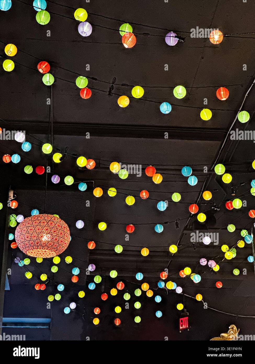 Mehrfarbige Lichter und ein Kronleuchter als Discoball beleuchten eine Party in einem Ballsaal. Stockfoto