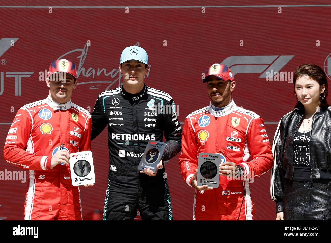 Shanghai, China. 14. März 2026. Der chinesische Hürdenläufer Wu Yanni (R1) posiert für ein Foto mit George Russell (L2) vom Mercedes-AMG Petronas Formel-1-Team, dem zweitplatzierten Charles Leclerc (L1) vom Scuderia Ferrari HP Formel-1-Team und dem drittplatzierten Lewis Hamilton vom Scuderia Ferrari HP Formel-1-Team nach dem Sprint-Rennen während des Formel-1-Grand Prix 2026 auf dem Shanghai International Circuit am 14. März 2026 in Shanghai, China. Der große Preis der Formel 1 von China 2026 findet vom 13. Bis 15. März auf dem Shanghai International Circuit statt. Quelle: Yin Liqin/China News Service Stockfoto