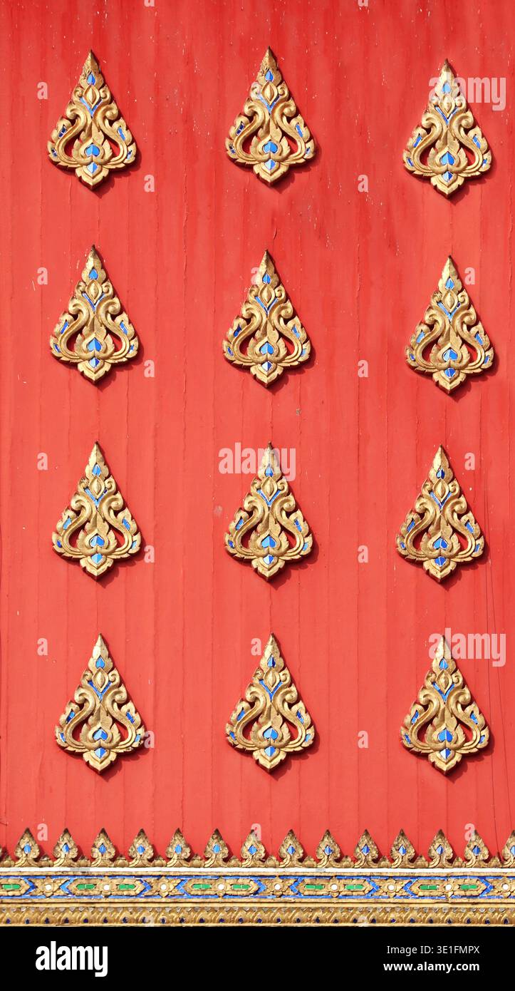 Detail der alten Holzwand mit geschnitztem Ornament im Tempel, Thailand. Eine hölzerne Tempelwand mit traditionellem thailändischem Dekor Stockfoto