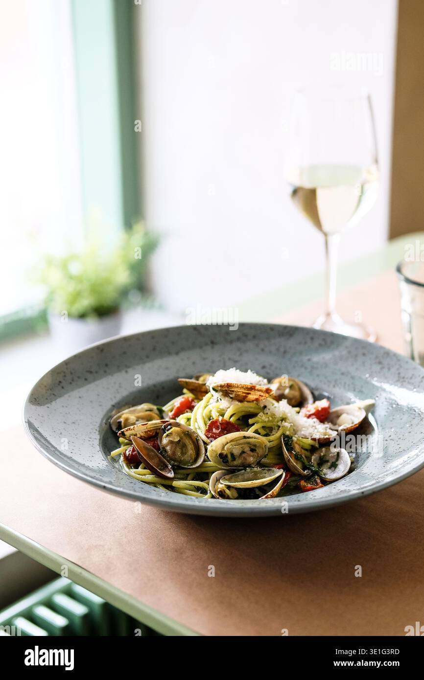 Elegantes Mittagessen Mit Meeresfrüchten. Legere Pasta Mit Muscheln. Entspannte Mittagsmahlzeit Mit Kräutern, Zitrusfrüchten Und Wein Stockfoto