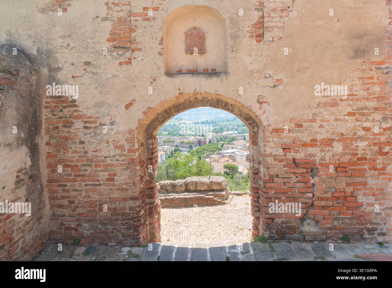 Historischer Steinbogen, der die ländliche Landschaft in der Stadt des europäischen Kulturerbes umrahmt. Image unterstützt kulturelle Bildung, Tourismusförderung und Architektur Stockfoto