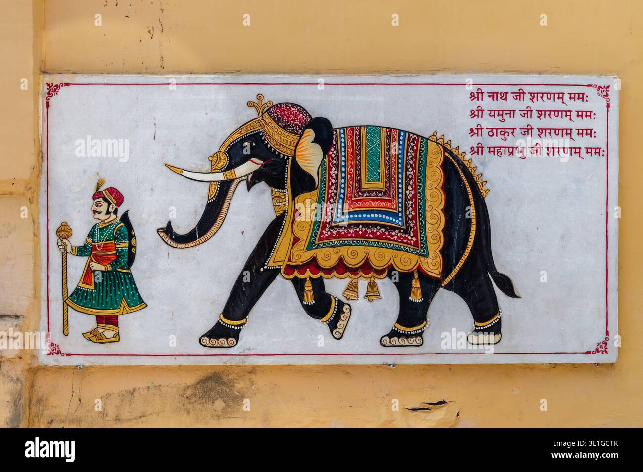 Dieses traditionelle Wandgemälde in Jodhpur zeigt einen dekorierten zeremoniellen Elefanten, der von einem königlichen Begleiter mit einer Keule geführt wird. Stockfoto