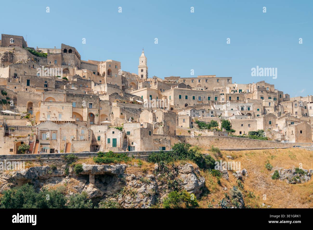 Matera, Italien: Historische Höhlenhäuser und Kathedrale von Sassi unter einem hellblauen Himmel Stockfoto