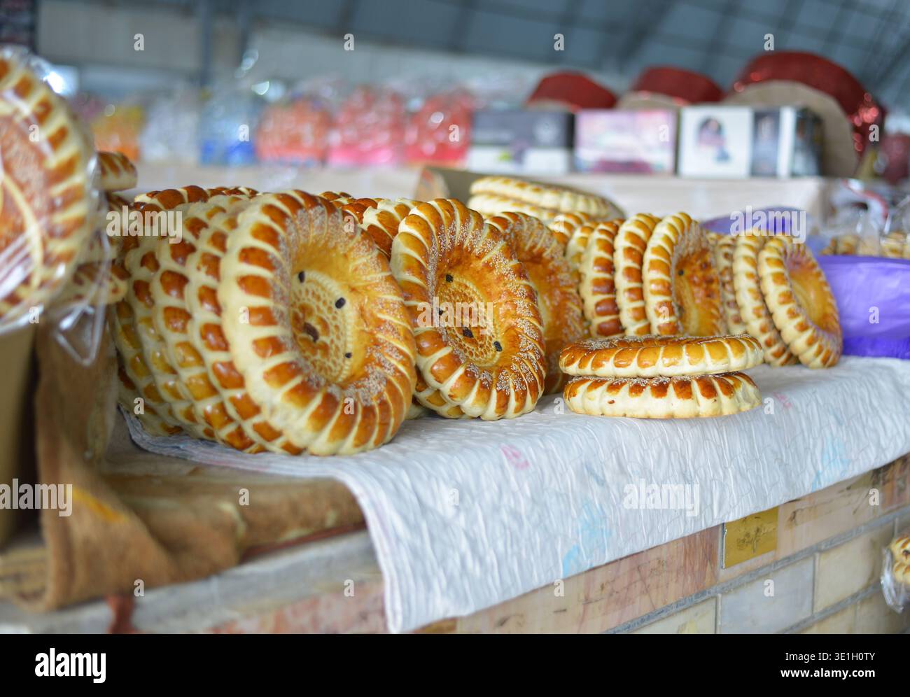 Eine Theke mit traditionellem usbekischen Brot. Rundes Fladenbrot Fladenbrot auf weißem Tuch auf dem Markt. Hochwertige Fotos Stockfoto