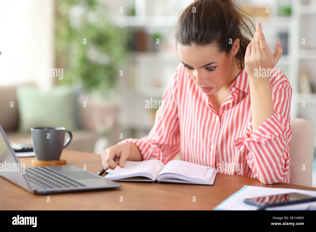Verwirrte Selbstständige, die die Tagesordnung überprüfen, zu Hause arbeiten Stockfoto