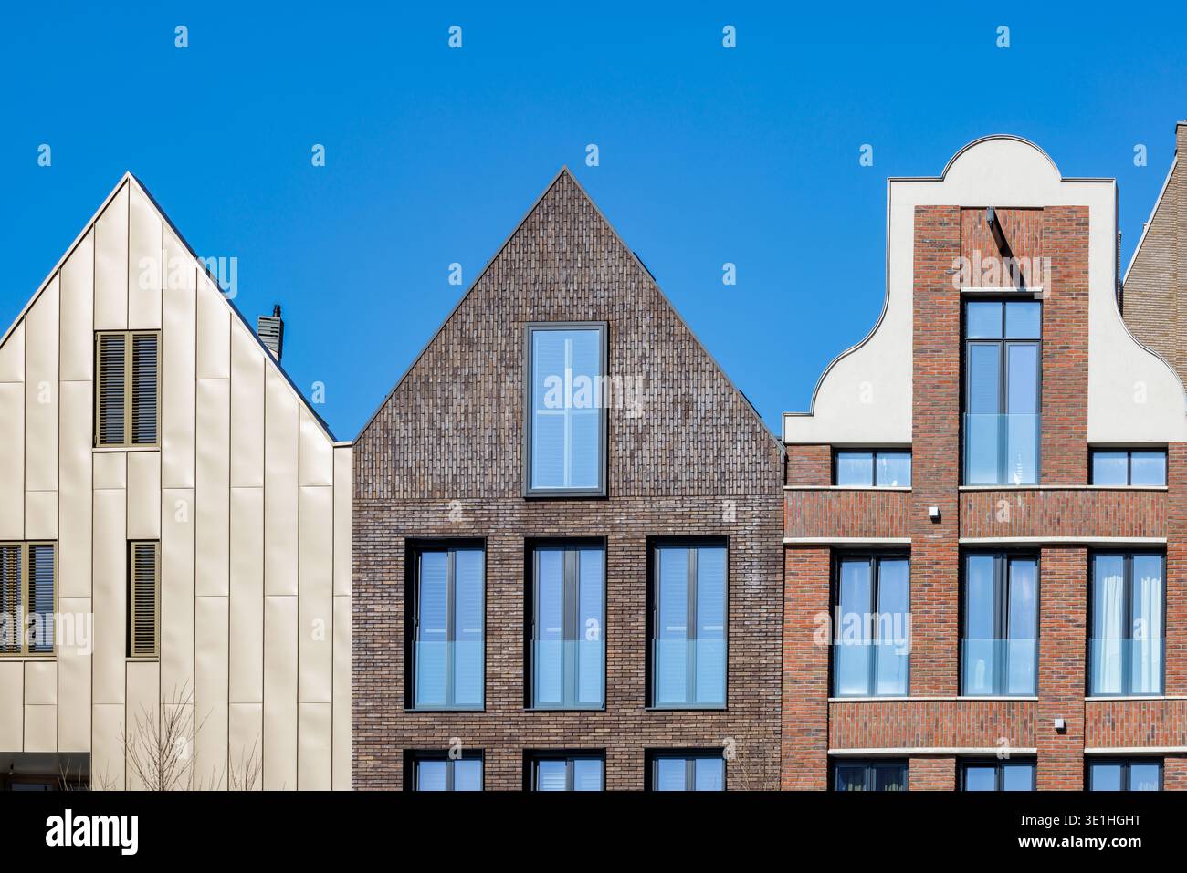 Neu gebaute zeitgenössische Kanalhäuser vor einem blauen Himmel in Zwolle, Niederlande Stockfoto