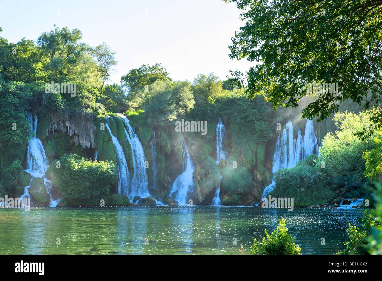 Ljubuški, Bosnien und Herzegowina - 26. Juni 2021: Wasserkaskaden des Kravica-Wasserfalls, der in einen türkisfarbenen See in Herzegowina mündet Stockfoto