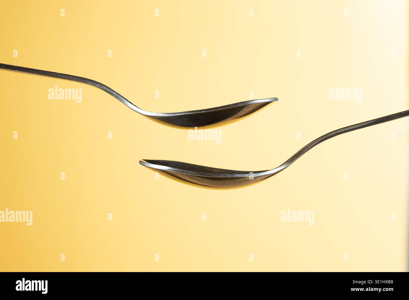 Zwei leere Löffel auf gelbem Hintergrund für Design Stockfoto