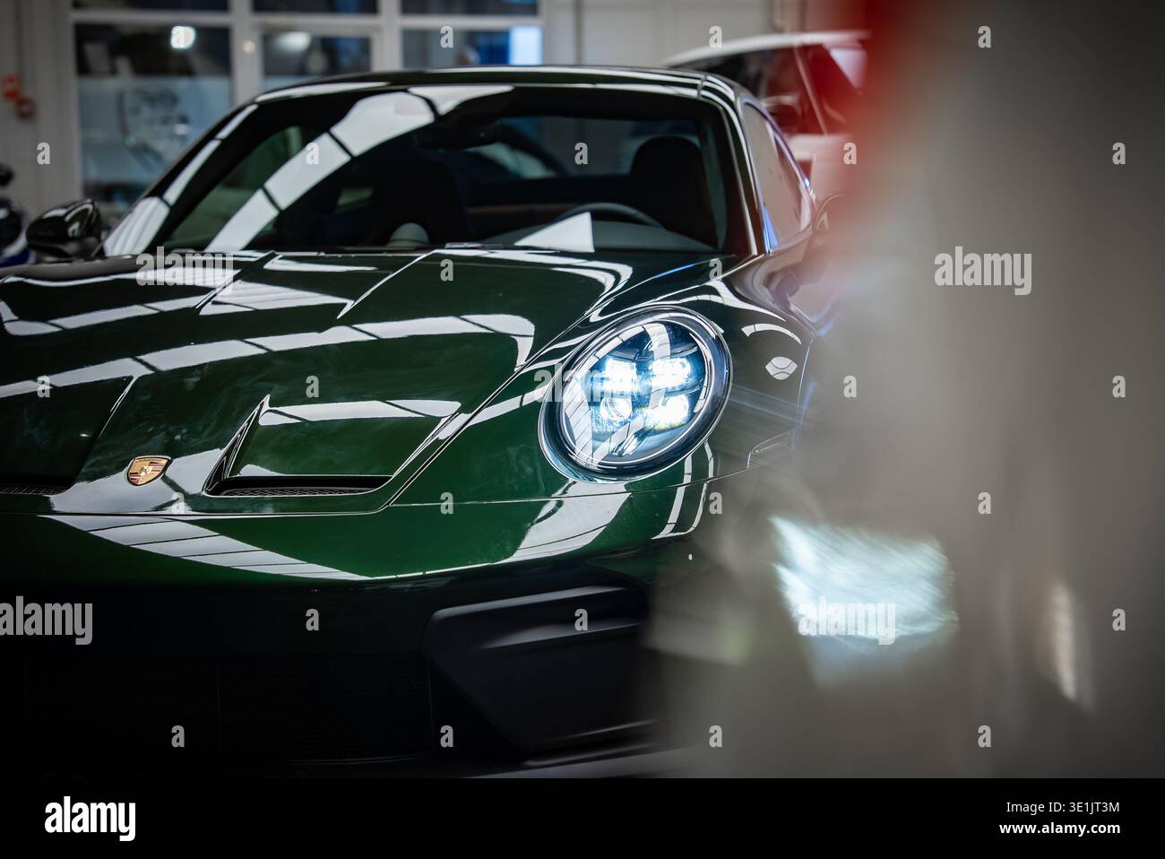 Dunkelgrüner Porsche 911 GT3 Touring in heller Werkstatt, Vorderansicht Stockfoto