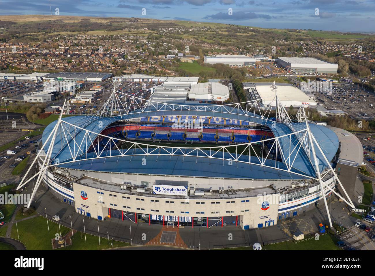 Luftaufnahme des legendären Bolton Wanderers Fußballstadions, eingebettet in die sanften grünen Hügel der Lancashire Landschaft. Stockfoto
