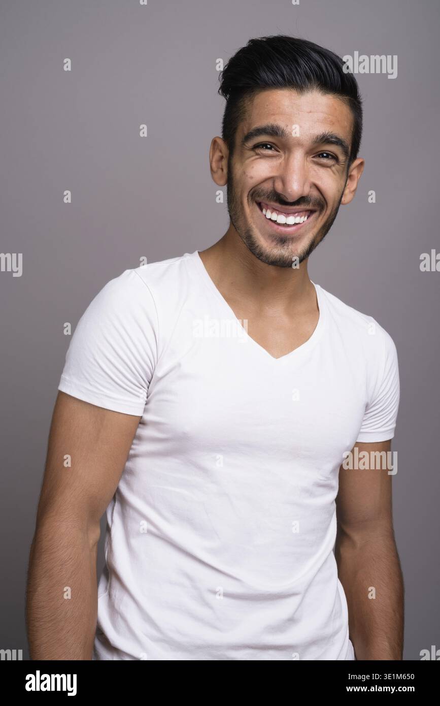 Studio shot der jungen schönen persischen Mann gegen grauer Hintergrund Stockfoto
