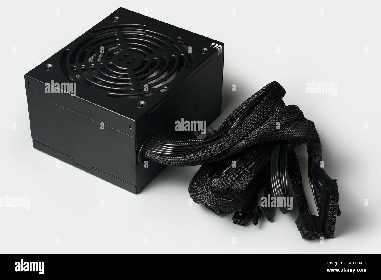Schwarzes atx pc-Netzteil mit Lüfter und Kabelbündeln isoliert hellgrauer Hintergrund, elektrische Komponente der Computerhardware, Winkelansicht Stockfoto