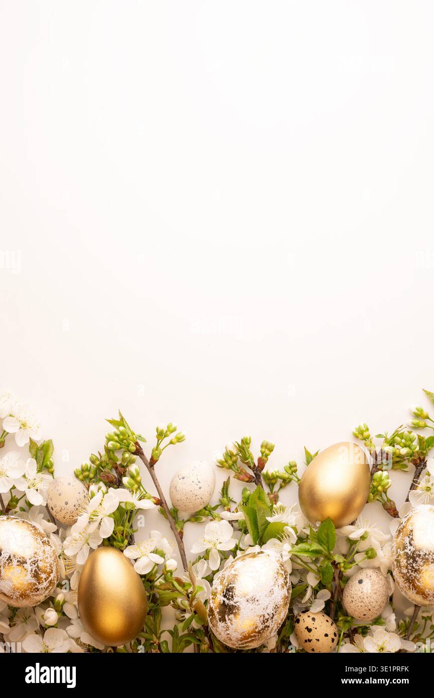 Goldene und gesprenkelte Eier werden zwischen weißen Blüten auf weißem Hintergrund platziert. Diese Szene ist für die Osterferien während der Frühlingssaison geplant Stockfoto