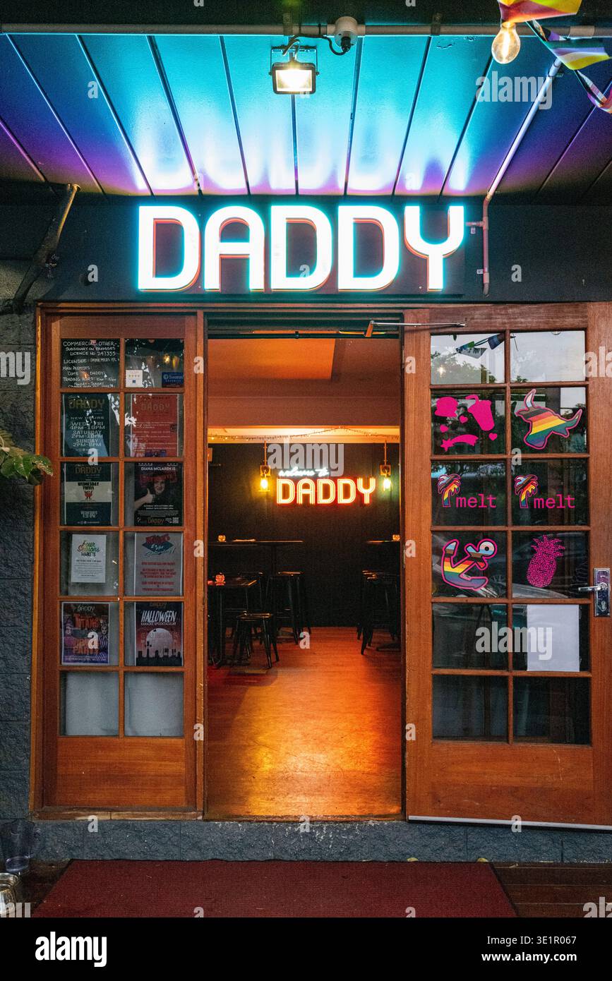 Eintritt zur Come to Daddy LGBTQ+ Bar in Brisbane, Australien. Das Foto zeigt die Neonschilder und die Stolz-Aufkleber an den Eingangstüren des West End. Stockfoto