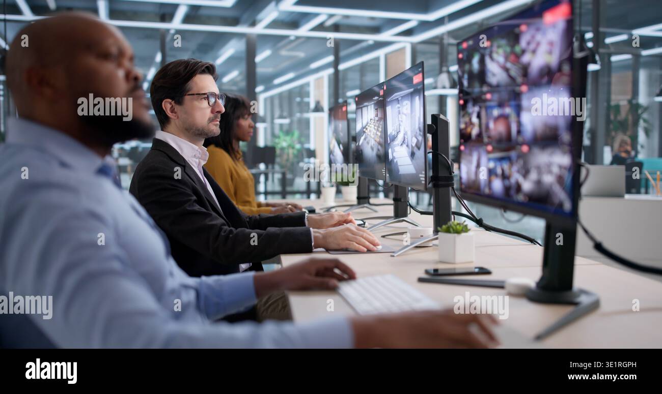 Im Sicherheitsraum untersucht Eine junge Frau Videomaterial auf mehreren Monitoren Stockfoto