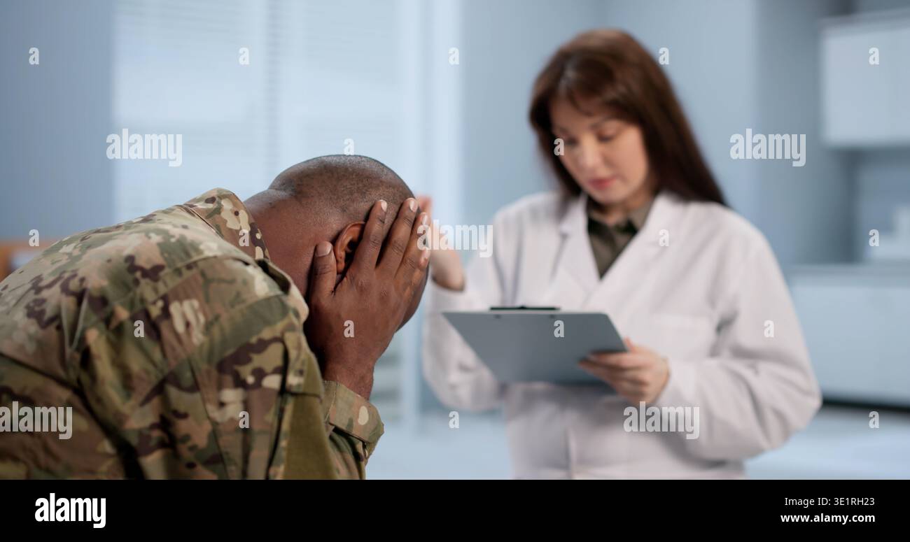 Soldat Und Arzt Sitzen Zusammen Und Diskutieren Über Therapie Und Psychische Unterstützung. Sie könnten Ratschläge zur PTBS geben Stockfoto
