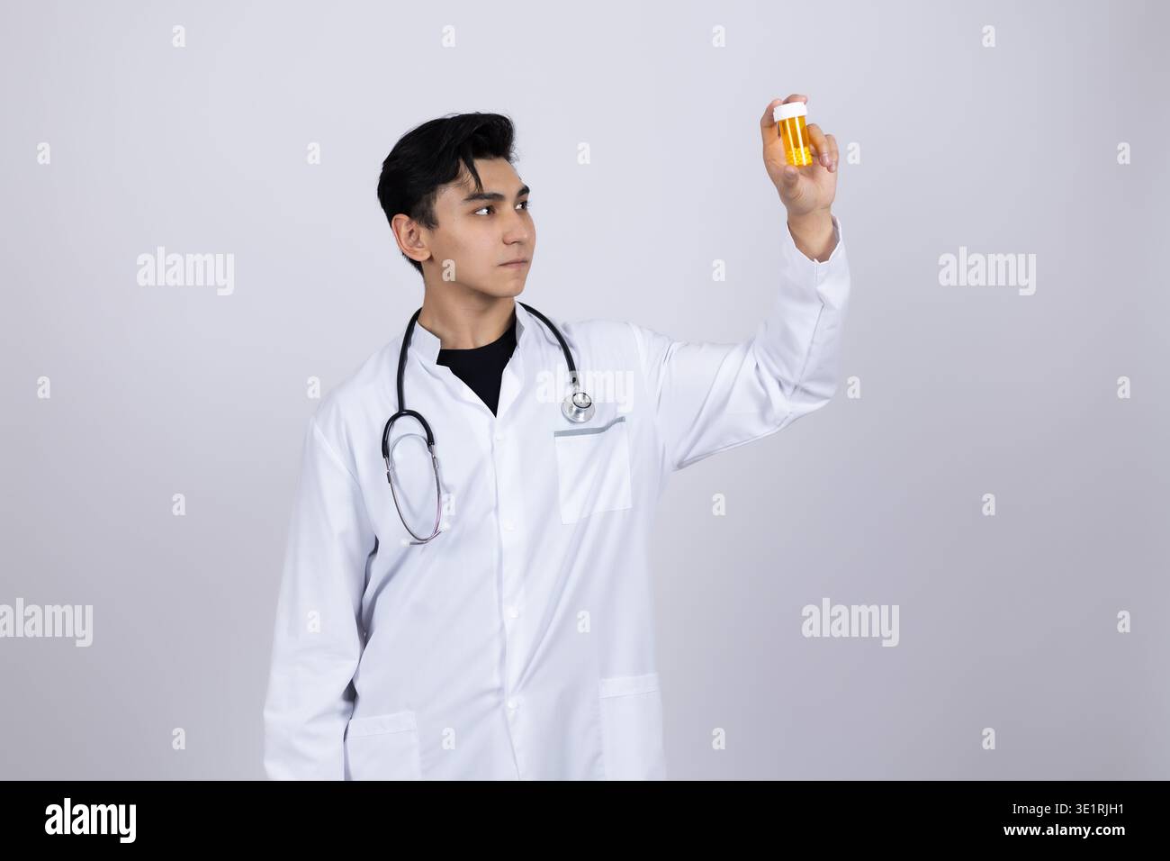 Doktor im weißen Mantel, der eine Orange hält Stockfoto